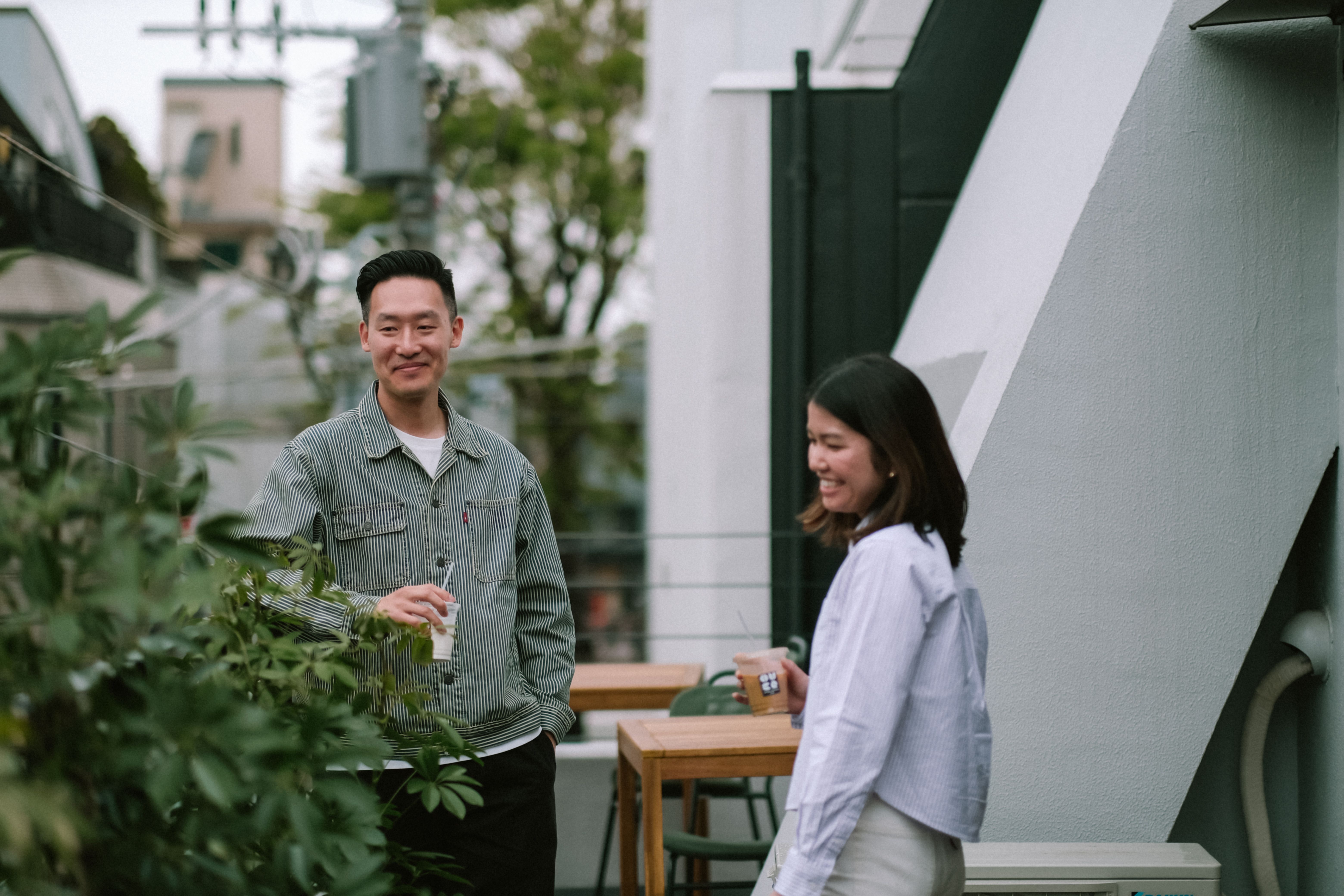 Two people enjoying drinks on the Over Coffee balcony